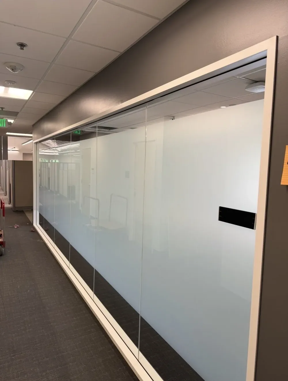 A long frosted glass office partition running down a corridor.